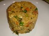 A picture of Spicy vegetable rice with egg and sausage.