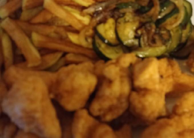 A picture of Fried Cajun chicken with homemade fries and courgette.