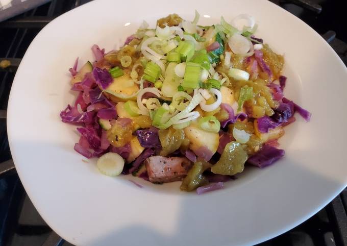 A picture of Italian sausages and vegetable skillet with spicy green harissa.