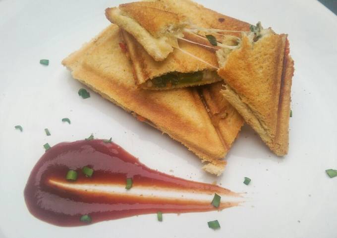 A picture of Sauteed vegetable sandwich toasted sesame seeds and tomato sauce.