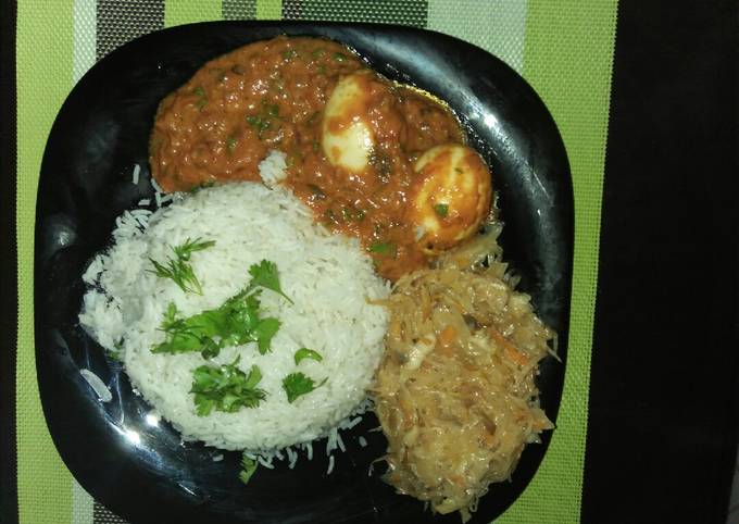 A picture of Rice,Egg Curry and cabbage.