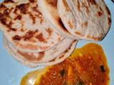 A picture of Naan bread with pumpkin soup.