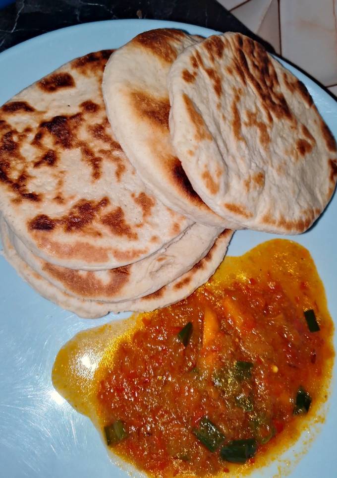 A picture of Naan bread with pumpkin soup.