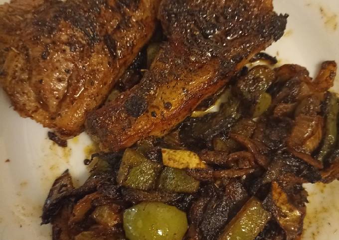 A picture of Lamb chops with onions and green pepper.