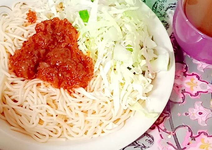 A picture of Sphagetti and vegetables with spiced tea.