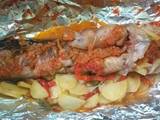 A picture of Grilled fish with potatoes and vegetables.