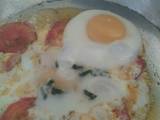 A picture of Sunny side up Eggs with tomato.