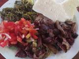 A picture of Nyama choma with traditional vegetables and Kachumbari.