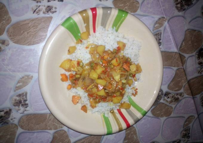 A picture of White rice with vegetable soup.