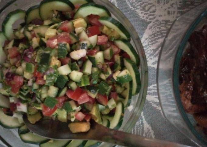 A picture of Cucumber, tomatoes, onions, avocado salad.