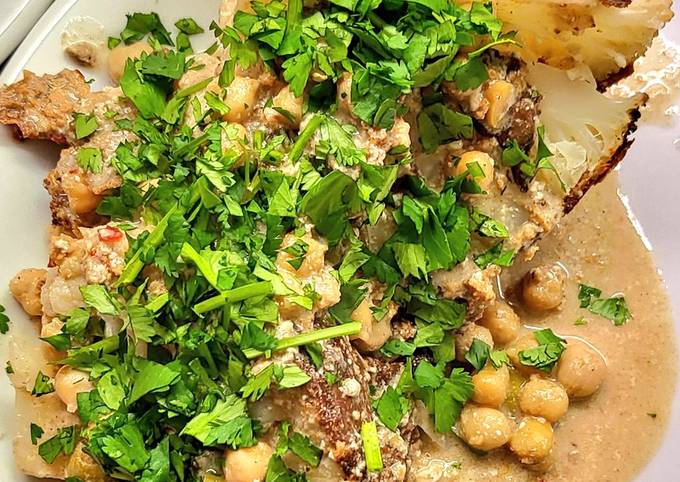 A picture of Whole roasted cauliflowers with peanut butter curry sauce.