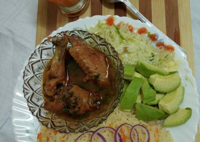 A picture of Kienyeji chicken with carrot rice and steamed cabbage.