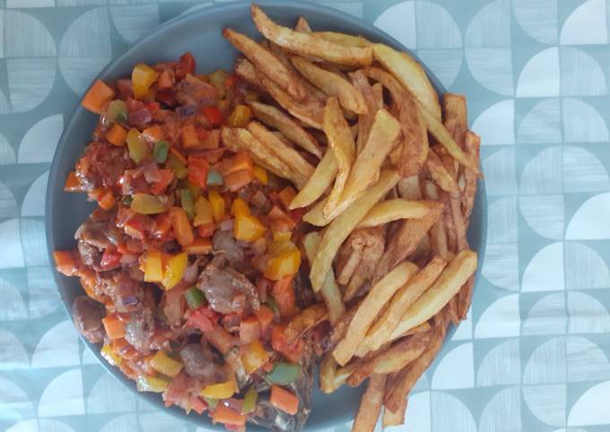 A picture of Potato chips and fried fish with peppered soup garnish with vegetables.