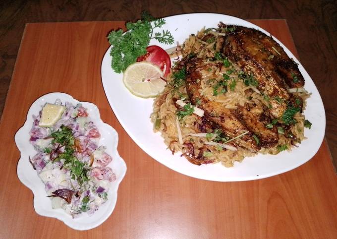 A picture of Fish vegetable biryani 🐟🥕🧅🍅🍋🧄and yoghurt kachumbari 🥗.