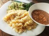 A picture of Carrot cumin rice served with peanut sauce and veggies.