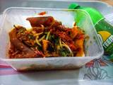 A picture of Roasted yam garnished with vegetable and ponmo sauce.