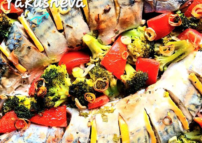 A picture of Mackerel in sour cream, with broccoli and tomatoes, in the oven.