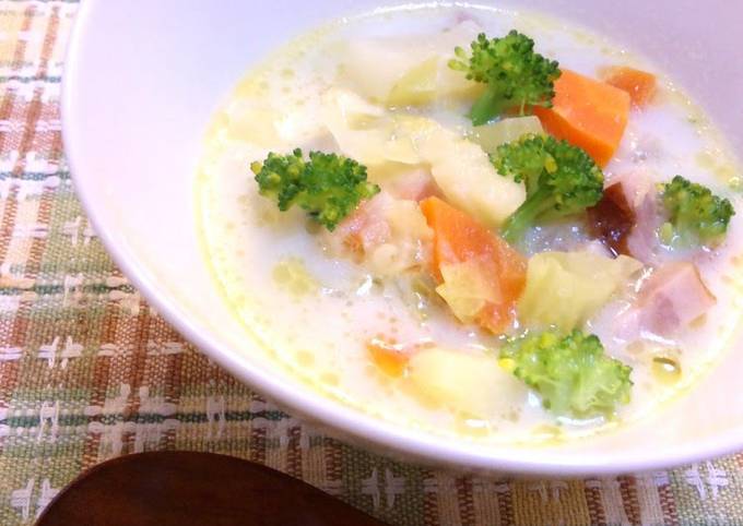 A picture of A chowder full of vegetables with bacon and welsh onions.