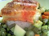 A picture of Broiled white fish over rice and vegetables.