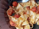 A picture of Homemade pasta with cherry tomatoes sauce.