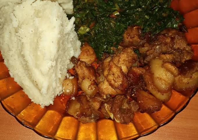 A picture of Ugali, fried pork and vegetable (sukuma wiki)# vegetables.