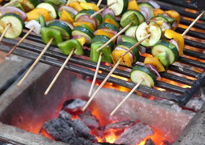 A picture of Grilled veggies and a 1/4 chicken.