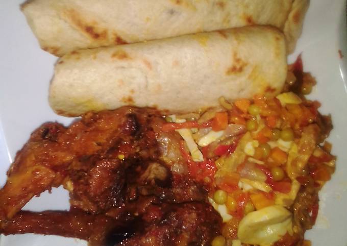 A picture of Flat bread, fried chicken with side vegetable sauce.