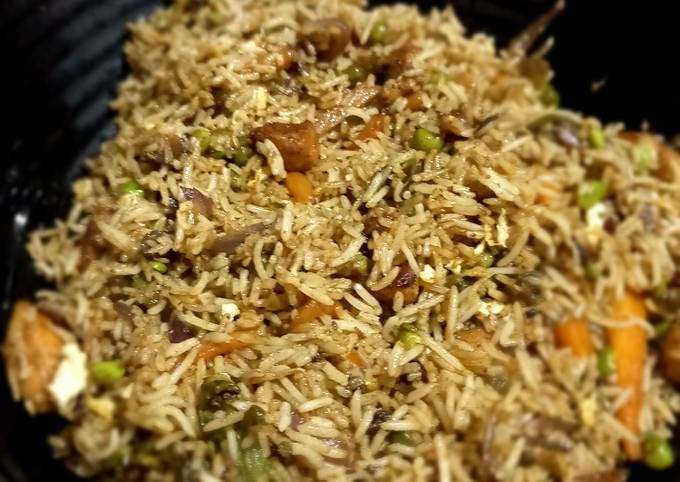 A picture of Vegetable and chicken fried rice.