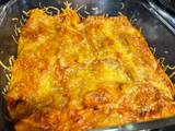 A picture of Chicken enchiladas with red sauce.