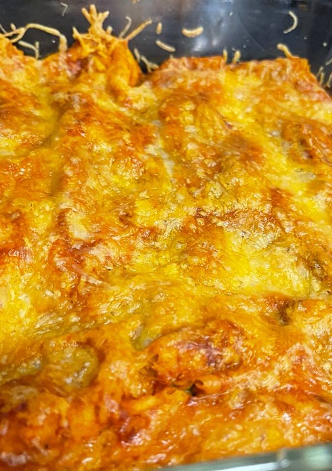 A picture of Chicken enchiladas with red sauce.