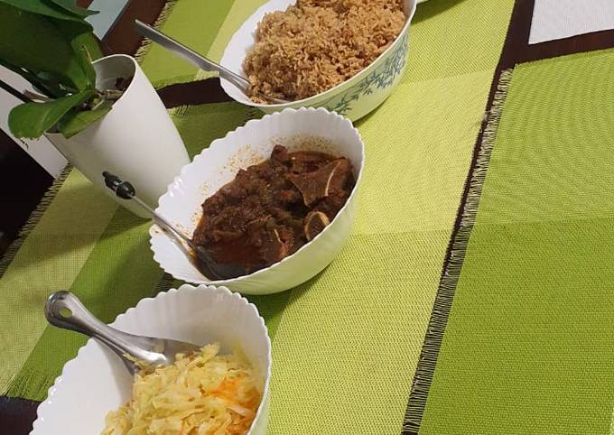 A picture of Pilau, beef stew, carroted cabbage and chapati.