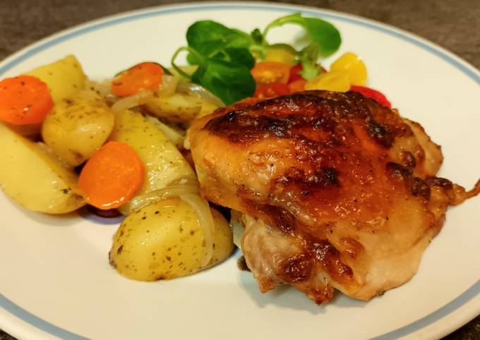 A picture of Chicken thighs in "onion" mayonnaise with vegetables, in the oven.