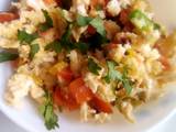 A picture of Simple scrambled eggs with onions, tomatoes and capsicum.