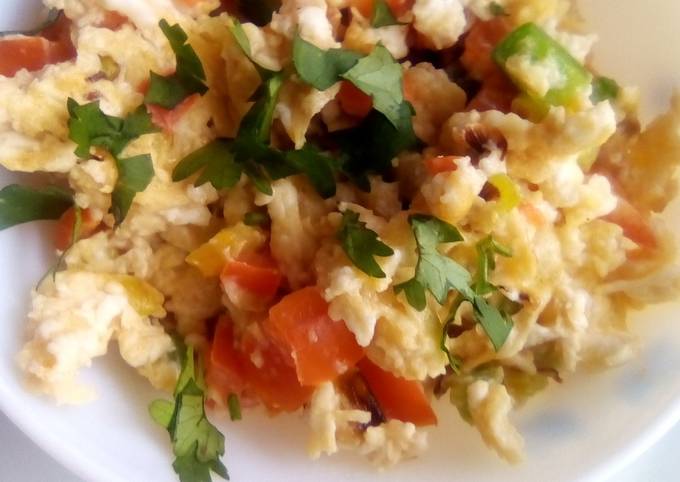 A picture of Simple scrambled eggs with onions, tomatoes and capsicum.