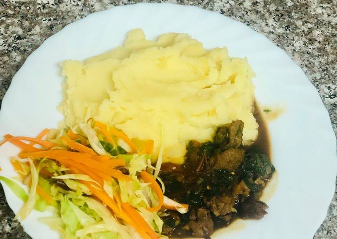 A picture of Creamy Mash Potato with Beef stew and Fresh vegetables.