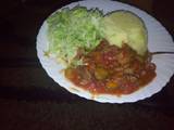 A picture of Mashed potatoes, beef stew n steamed cabbages.