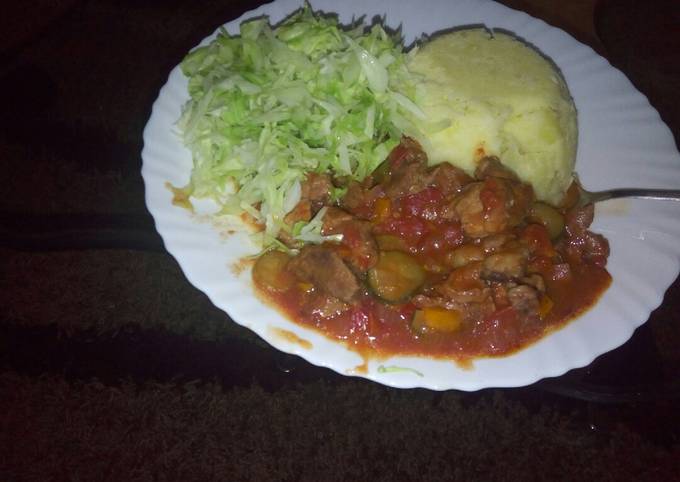 A picture of Mashed potatoes, beef stew n steamed cabbages.