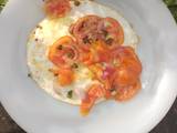 A picture of Fried Egg Garnished with Fresh Vegetables.