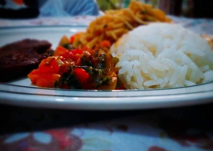 A picture of White rice and spaghetti with fried beef and vegetable sauce.