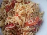 A picture of Fried noodles with tomatoes.