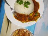 A picture of Egg curry served with white rice and sauted cabbage.