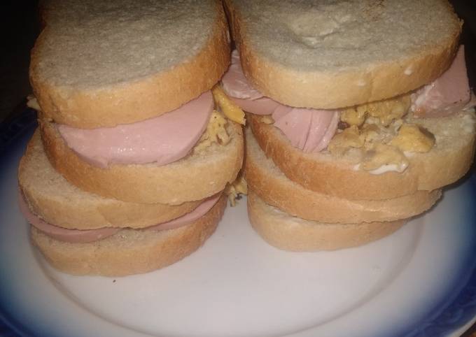 A picture of Homemade sandwich with mushroom eggs and salami.