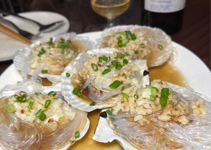 A picture of Steamed scallops with onion and glass noodles.