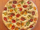 A picture of Foccacia with cherry tomatoes, rosemary and pomegranate molasses.