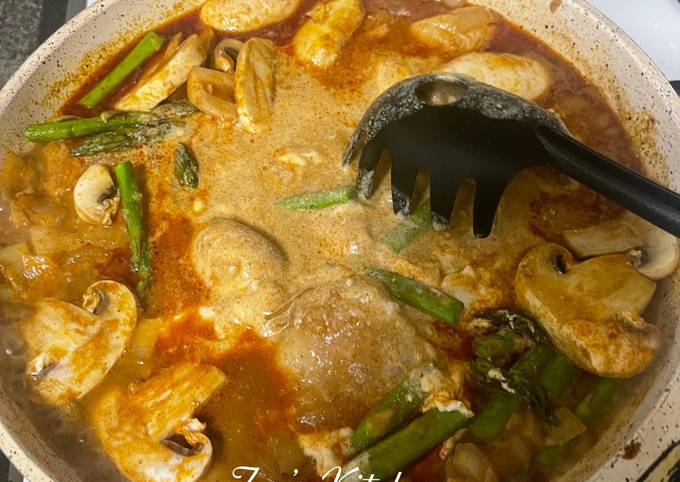 A picture of Fish Curry with mushroom and asparagus.