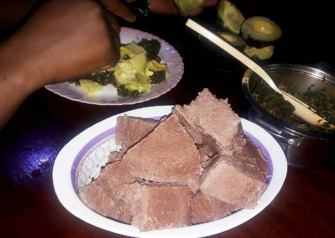 A picture of Brown ugali with veggies and meat.