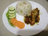 A picture of Fried chicken with vegetable rice.