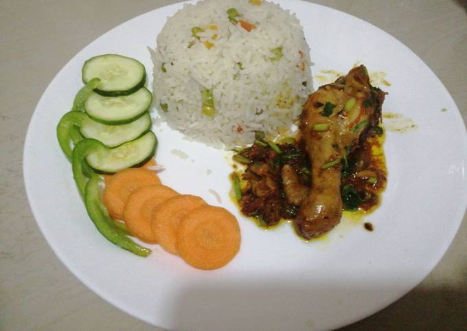 A picture of Fried chicken with vegetable rice.