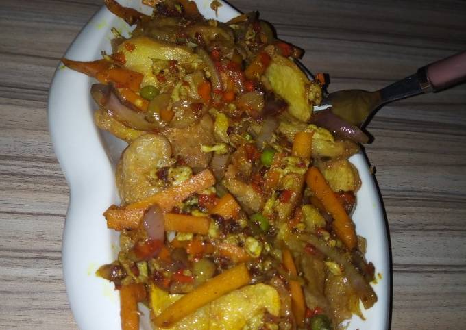 A picture of Fried potetos and veg. sauce.