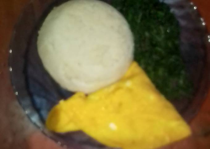 A picture of Ugali,fried eggs and green vegetables.